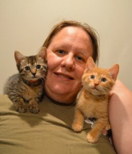 Volunteer with two kittens